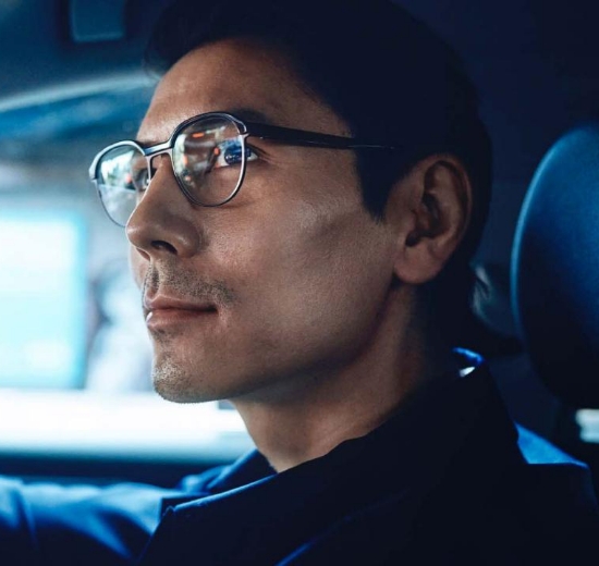 Mann mit Brille beim Autofahren.